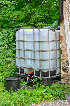 rainwater with big cubic tank with black bucket