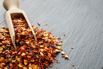 spicy chili flakes on a dark stone background