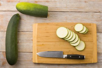 Slice the zucchini on a cutting board with a knife. Flat lay