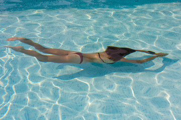 beautiful young woman relaxing by the tropical pool