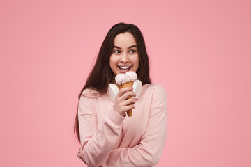 Excited teenage female smiling while eating yummy gelato