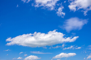 Naklejka na ściany i meble Hintergrund aus Wolkengebilden vor blauem Himmel.