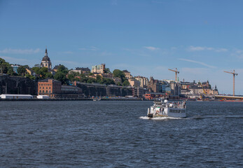 Fototapeta premium Old harbor ferry MS Kung Ring passing the island Djurgården a sunny for the archipelago summer day in Stockholm