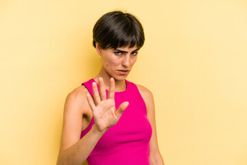 Young caucasian woman with a short hair cut isolated rejecting someone showing a gesture of disgust.