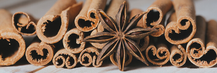 Traditional Christmas spices - Star anise with cinnamonon dark rustic wooden background banner