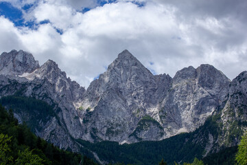 Fototapeta na wymiar The peaks of Triglav National Park in Slovenia. The peaks are in the sun. The sky is overcast but shows blue skies. Spik Peak is clearly visible.