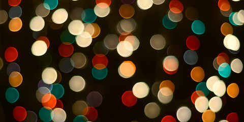 Christmas background is a dark table and blurred multicolored lights in the background.