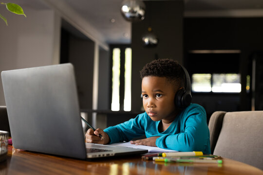 Image of african american boy learning and using laptop