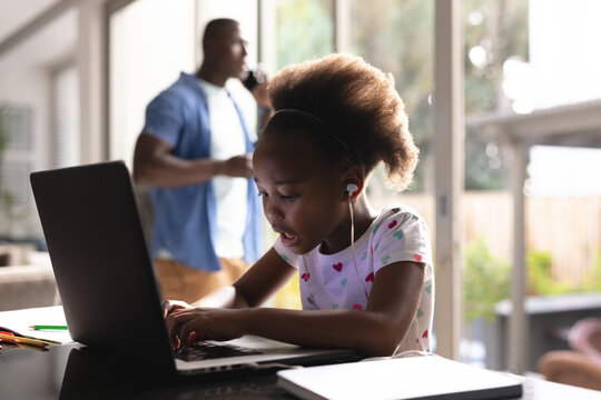 Image of african american father and daughter having online lessons and working together