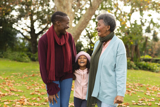 Image of happy african american grandmother, mother and daughter in garden