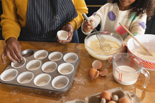 Image Of Happy African American Grandmother And Granddaughter Baking In Kitchen