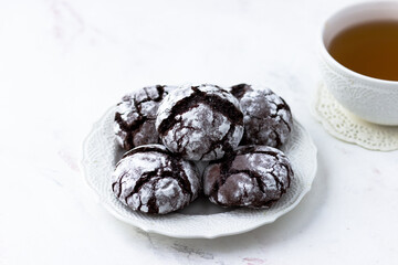Cookies chocolate cracks on a white marble table. Biscuits and a cup of tea