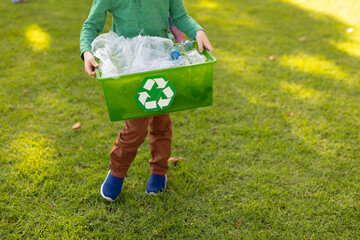 Image of midsection of caucasian boy with box for waste recycling