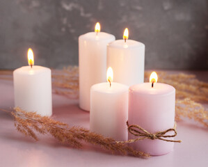 Obraz na płótnie Canvas Set of white and pink wax candles with dried flowers