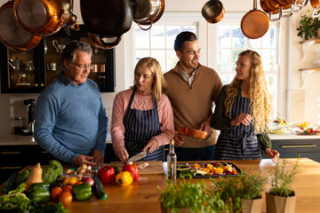 Image of happy multi generation caucasian family preparing dinner together