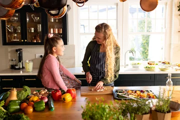 Foto op Canvas Image of happy caucasian mother and daughter preparing meal in kitchen © WavebreakMediaMicro