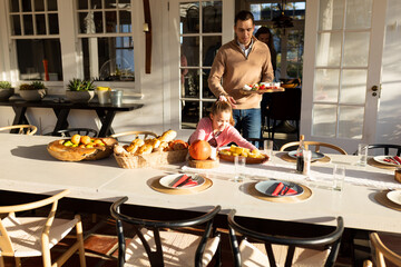 Image of caucasian father and daughter preparing outdoor dinner