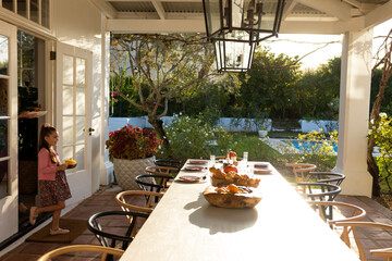 Image of caucasian girl preparing outdoor dinner on patio
