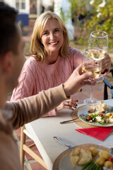Vertical image of happy caucasian woman toasting with wine with family