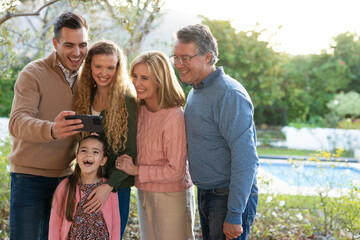 Obraz premium Image of happy multi generation caucasian family taking selfie after dinner on patio