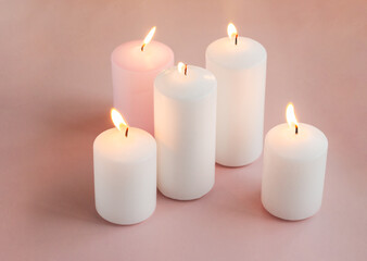 Fototapeta na wymiar Set of burning white and pink wax candles