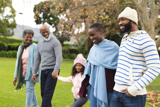 Image of happy multi generation african american family having fun outdoors in autumn