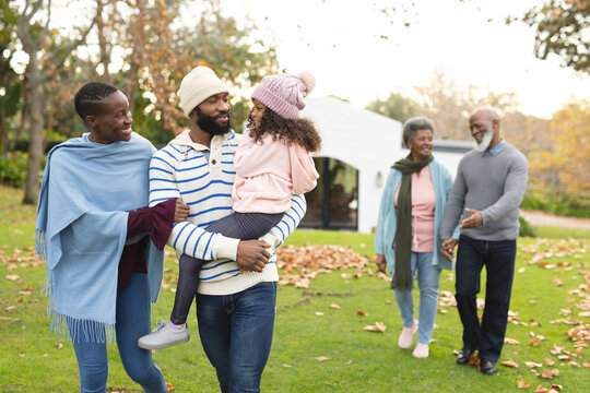 Image of happy multi generation african american family having fun outdoors in autumn