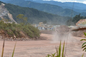 Heavy Mining Dump Truck Transporting Soil on Dusty Road in Open Pit Mine © robert ngatijo