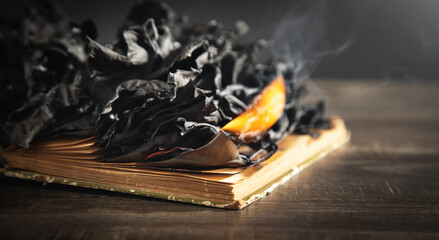 Burning book on the wooden table.