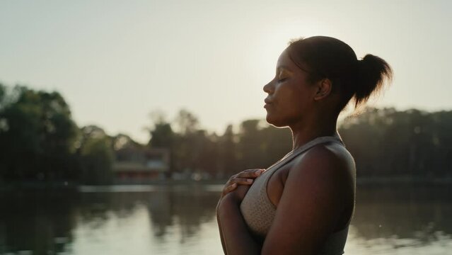 African American woman practicing breathing exercise at the park. Shot with RED helium camera in 8K.    