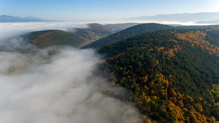 Aerial view of mountain in autumn season from above the clouds