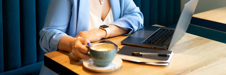 businesswoman. faceless beautiful young or mature professional career woman boss in business suit working on laptop. modern women entrepreneur working in restaurant and cafe small business. banner