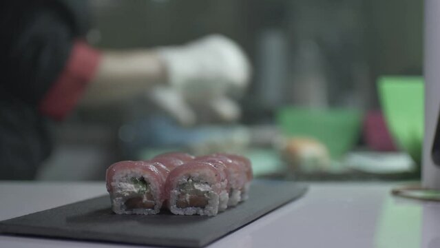 A Woman In Shef Clothes Preparing Sushi