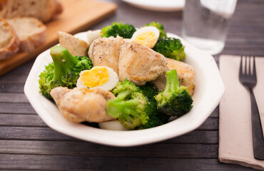 healthy appetizer of chicken pieces with broccoli and quail eggs in bowl for healthy lunch