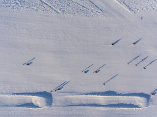 Aerial view of ski slope. People are skiing and snowboarding.