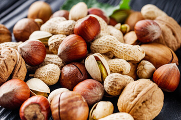 set of different nuts on a black rustic wooden background