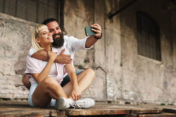 Fototapeta na wymiar Young happy couple taking a selfie in an urban environment