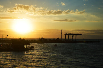 Obraz premium a sea pier at sunset, a beautiful summer horizon. the port is in the city. background for the design.
