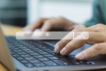 Close-up of a man's hands typing on a laptop keyboard. and has a white search icon The concept of...