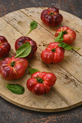 The harvest of assorted red tomatoes on a wooden table. 