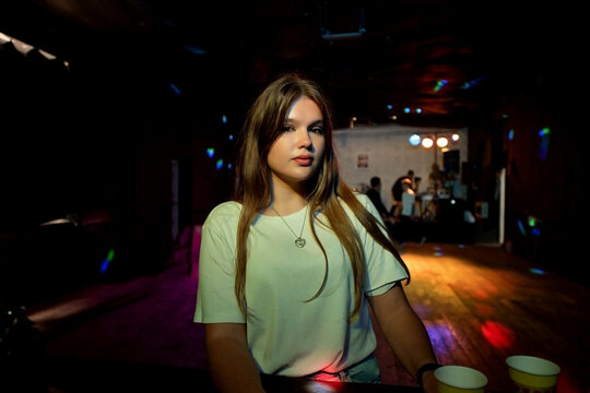 young girl in a white t-shirt at a party. teenage bad habits
