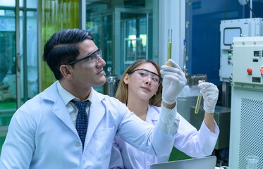 Scientists and assistants are in the oil and cannabis seed extractor room. The extracted cannabis oil is being tested and examined.