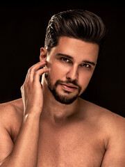 Beauty portrait of handsome, sexy male model with beard looking at the camera. Shirtless man.