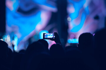 Fototapeta na wymiar Person holding modern smartphone on a concert.