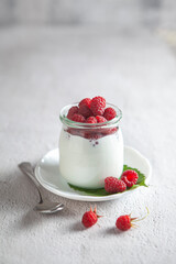 raspberry and cream dessert in the glass jar with spoon