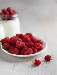 raspberries in a bowl with raspberry dessert behind