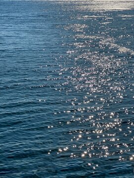 Sparkling blue sea waves surface at evening.