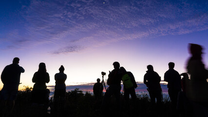 Silhouette group of people enjoying sunrise new year camping on mountain