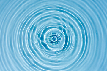 Naklejka na ściany i meble Texture of blue water with rings and ripples from drops