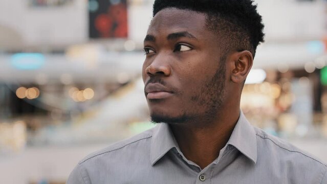 Close-up serious sad pensive worried young businessman looking away daydreaming african american man with thoughtful dreamy facial expression standing alone unhappy anxious guy thinking about problem